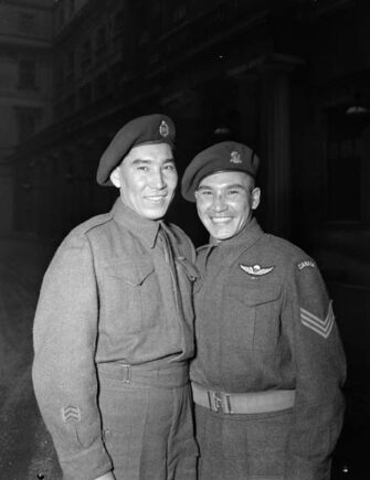 Tommy Prince (à droite), accompagné de son frère Morris (à gauche),
participent à une cérémonie de remise de médailles au
palais de Buckingham, le 12 février 1945 (source :
Bibliothèque et Archives Canada).